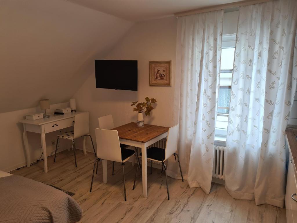 Schlafzimmer mit einem Tisch, einem Schreibtisch und einem Fenster in der Unterkunft Hotel Löhr in Baden-Baden