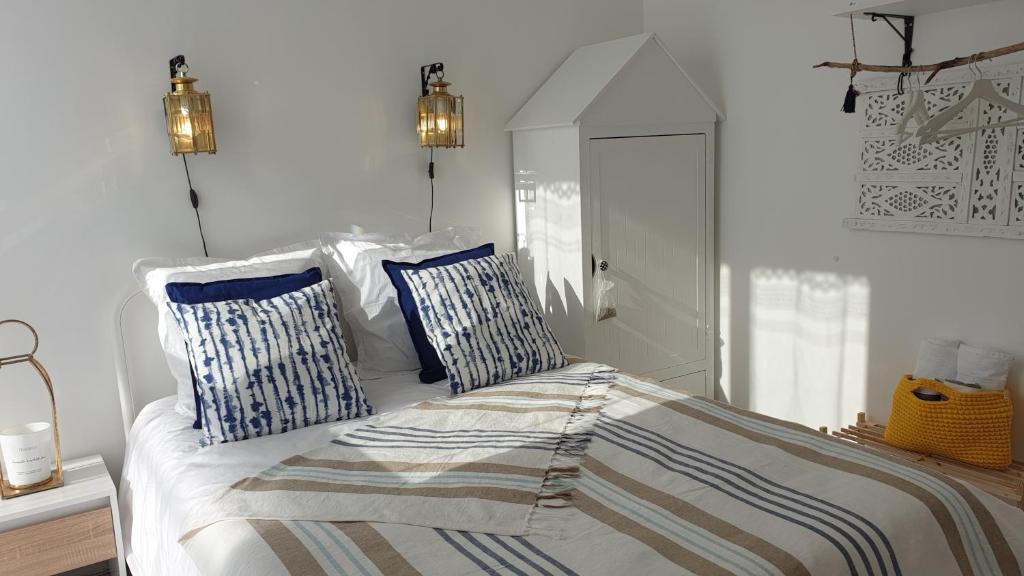 a bedroom with a bed with blue and white pillows at "Voyage en mer" splendide T3 lumineux, Wi fi et PARKING gratuit in Toulon
