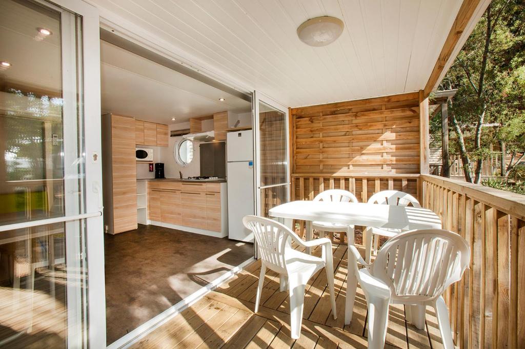 a balcony with a table and chairs and a kitchen at Camping la Croix du Sud in Saint-Tropez