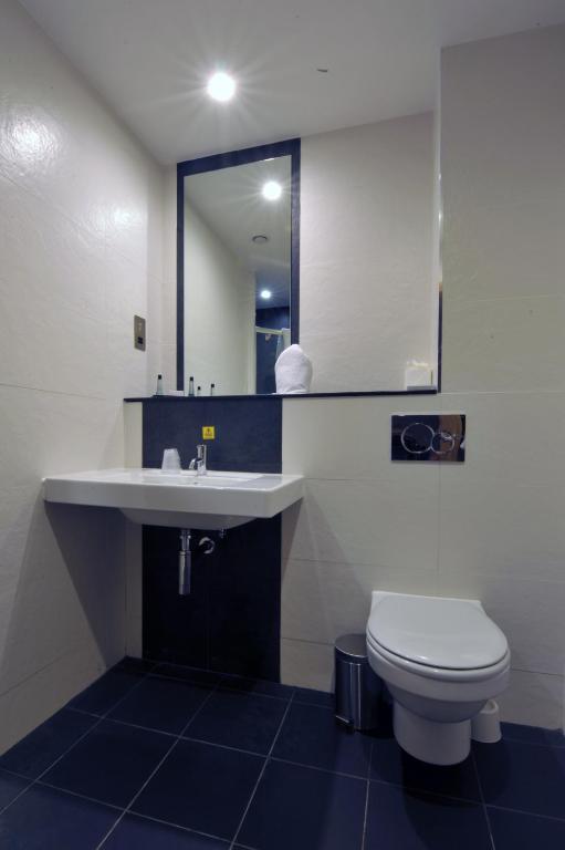 a bathroom with a sink and a toilet and a mirror at The Inn on Loch Lomond in Luss