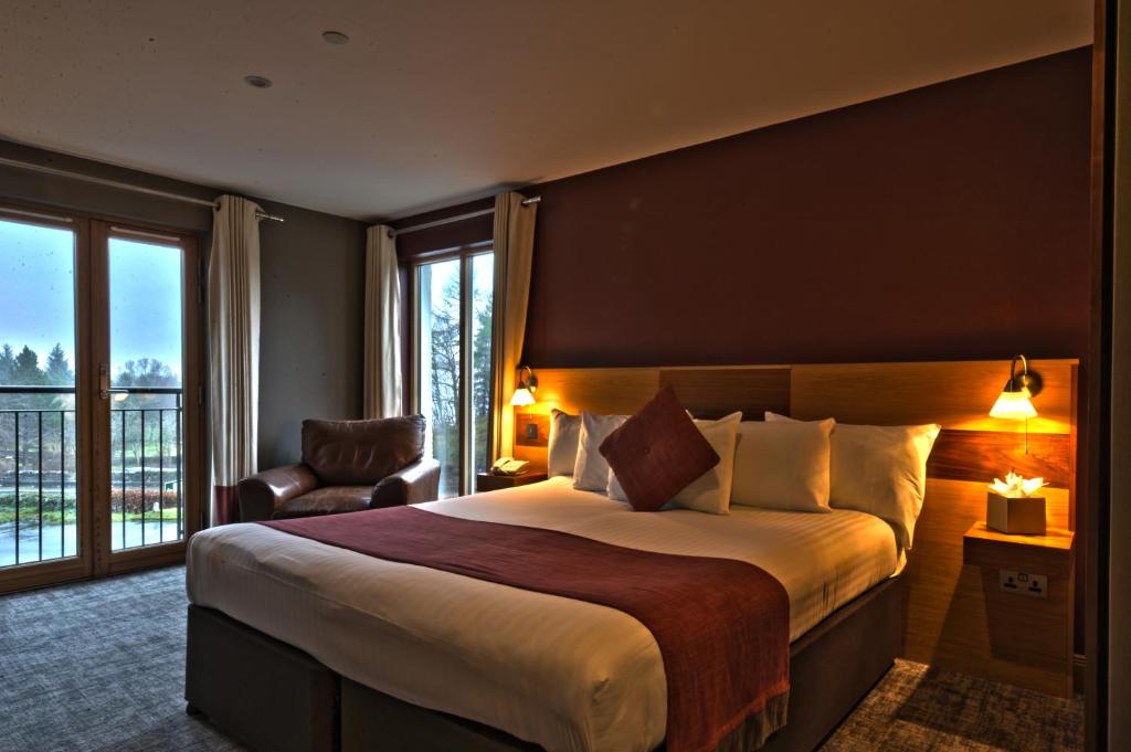 a hotel room with a large bed and a window at The Inn on Loch Lomond in Luss