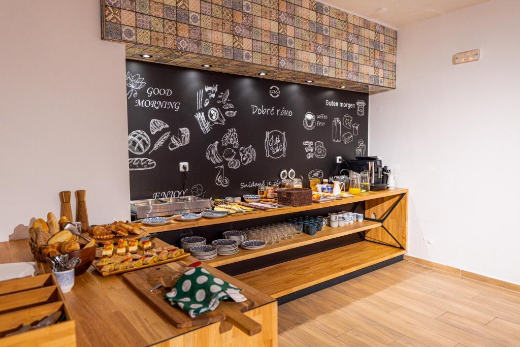 JEZ&SPI Sušice في سوشيتسا: مخبز مع جدار سبورة مع الطعام عليه