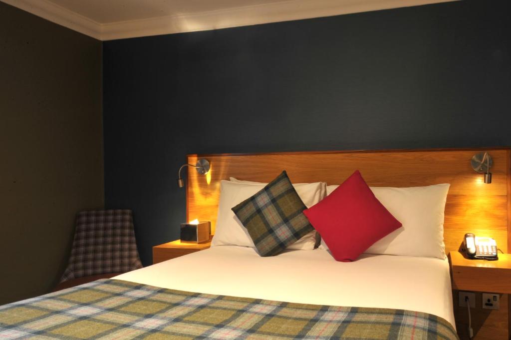 a hotel room with a bed with two pillows at The Inn on Loch Lomond in Luss