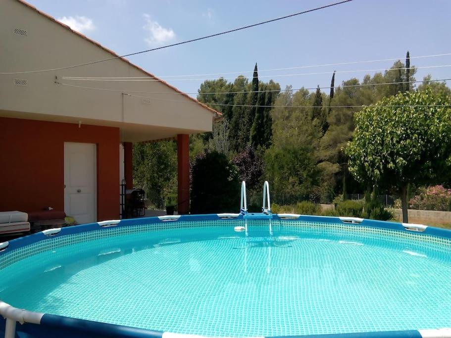 uma grande piscina azul numa casa em Casa junto al lago em Jérica