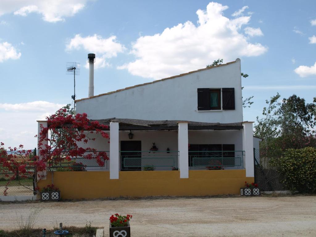 a white and yellow house with flowers on the side at Caseta de Susana in Deltebre