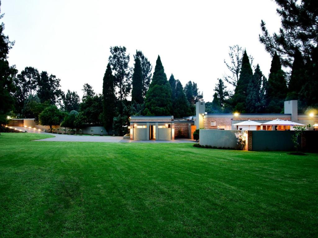 duży dziedziniec z domem z zielonym trawnikiem w obiekcie Five O'clock Zen Boutique Guest House w mieście Centurion