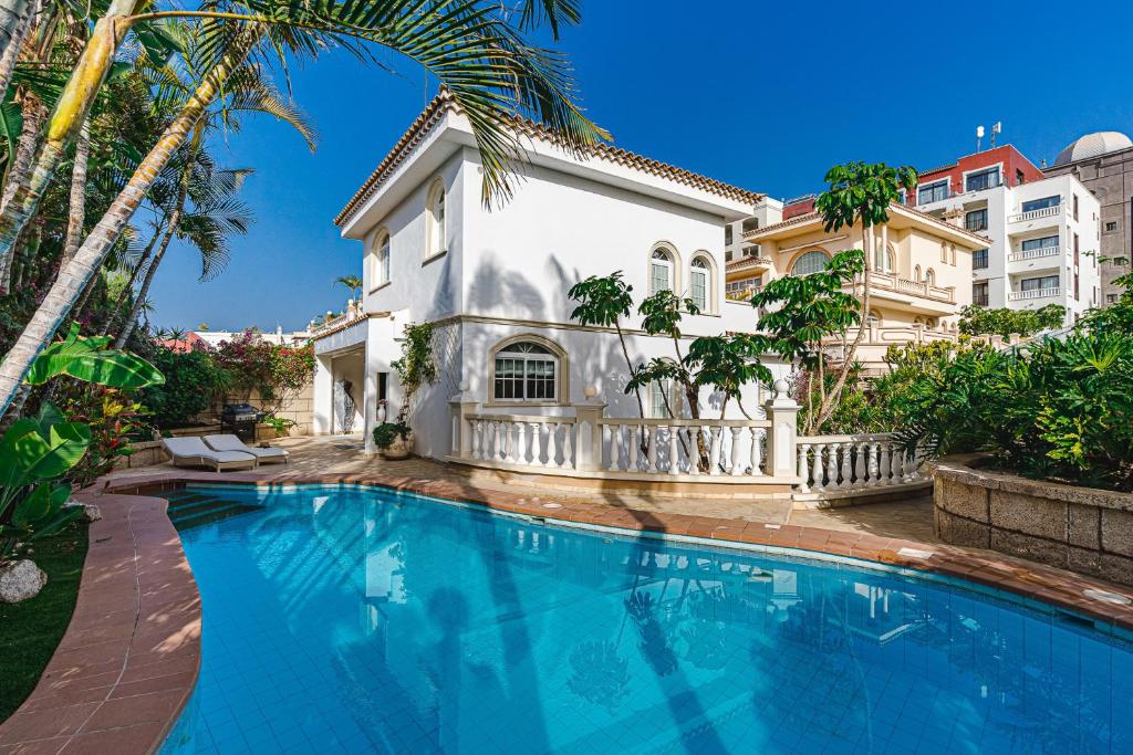 a large swimming pool in front of a house at Luxury villa El Duque in Adeje
