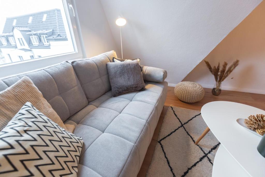 - un salon avec un canapé et une fenêtre dans l'établissement Bheaven I Skandi Premium Apartment, à Bremerhaven