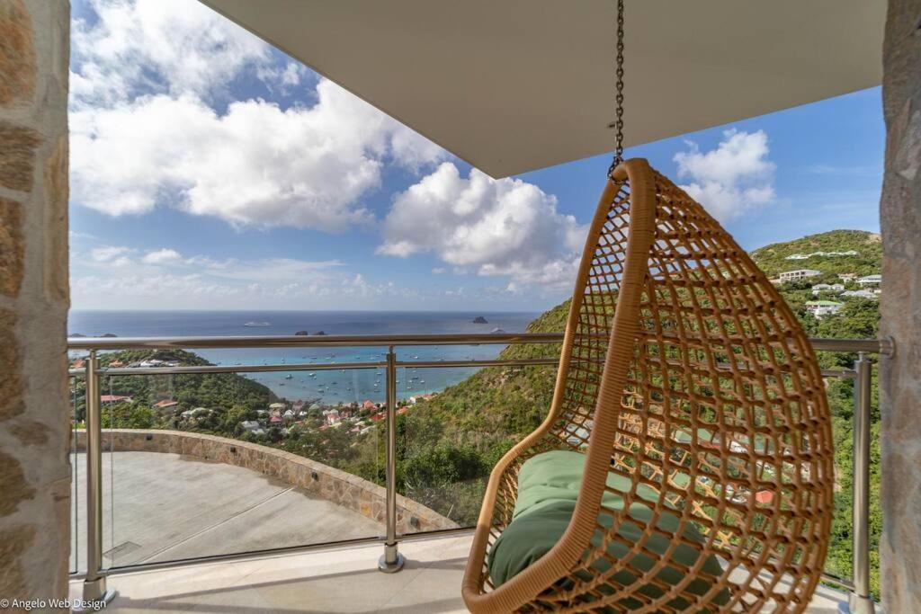 a hammock on a balcony with a view of the ocean at VILLA ANGEL ROCK in Saint Barthelemy