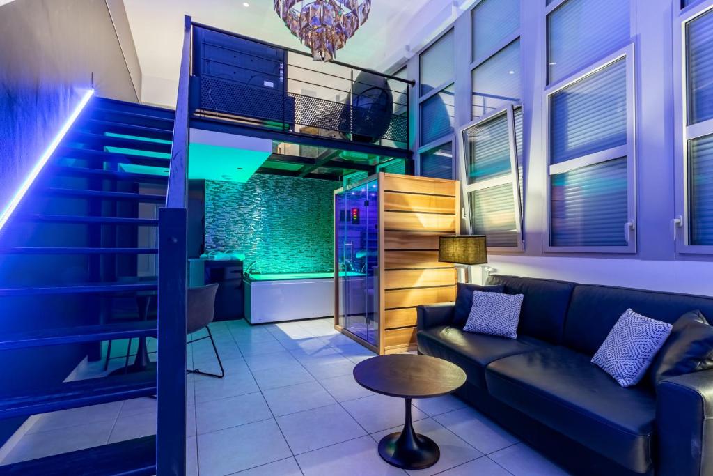 - un salon avec un canapé et des escaliers dans l'établissement GlamappartSpa Prestige New-York expérience, à Reims