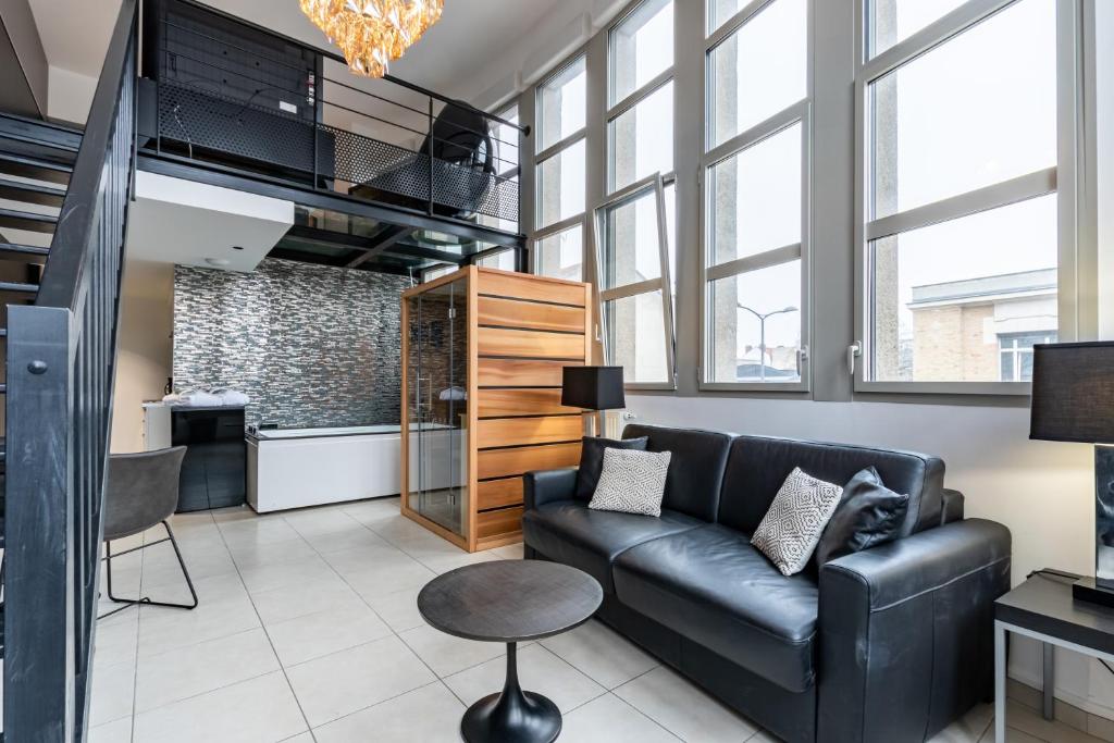 a living room with a couch and a table at GlamappartSpa Prestige New-York expérience in Reims