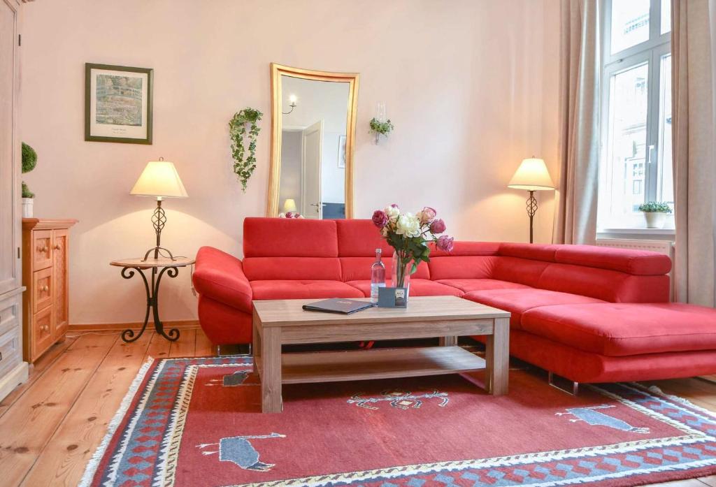 salon z czerwoną kanapą i stołem w obiekcie Villa Magdalena 02 w mieście Ahlbeck
