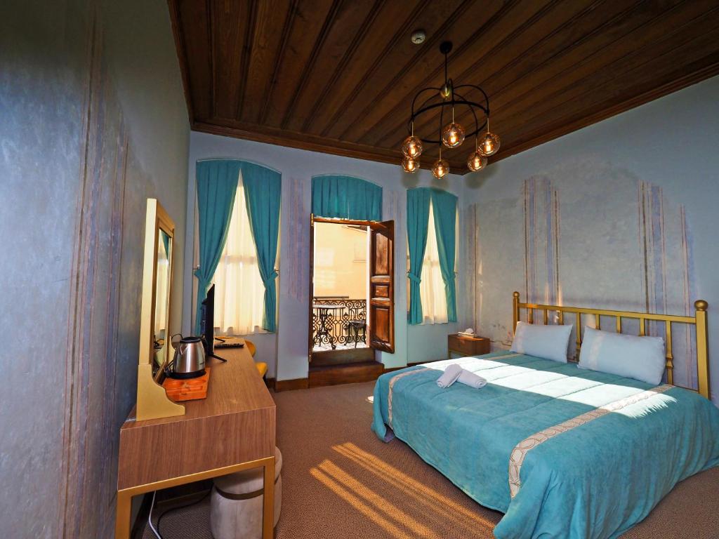 a bedroom with a bed with blue walls and a chandelier at Taksim Estane Butik Otel in Istanbul