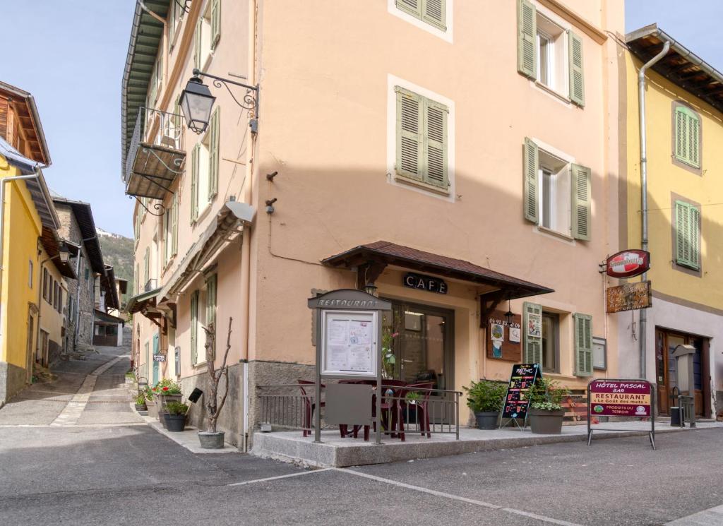 a building with a table and chairs in a street at Hotel Pascal in Allos