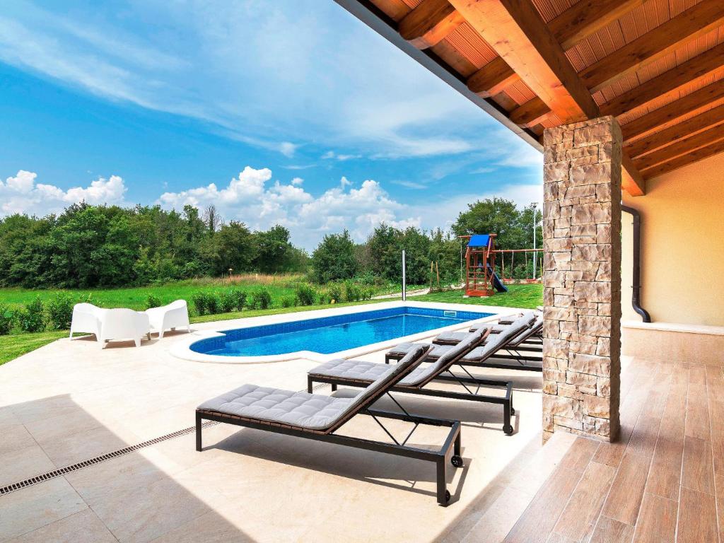a patio with lounge chairs and a swimming pool at Holiday Home Jadran - LBN310 by Interhome in Nedeščina