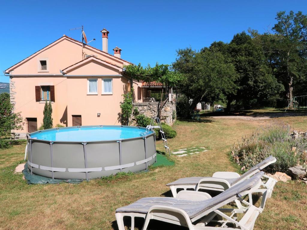 - un groupe de chaises longues et une piscine en face d'une maison dans l'établissement Holiday Home Nino - LBN305 by Interhome, à Kršan
