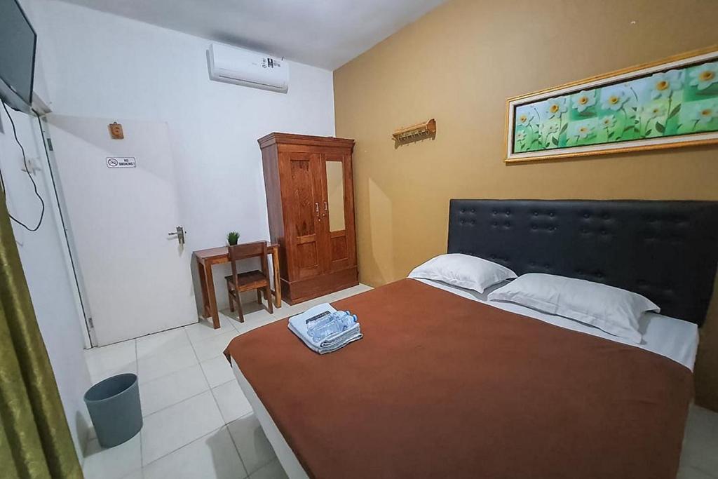 una camera con un grande letto e un bagno di Syafa Homestay Syariah Mitra RedDoorz a Jembel