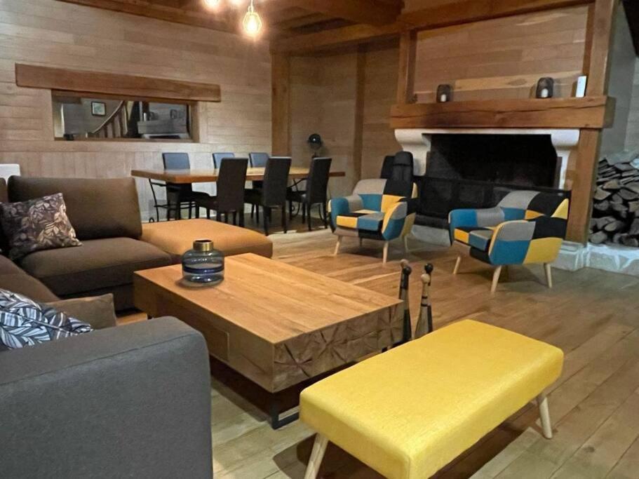 Habitation en bois authentique في Venizy: غرفة معيشة مع أريكة ومدفأة