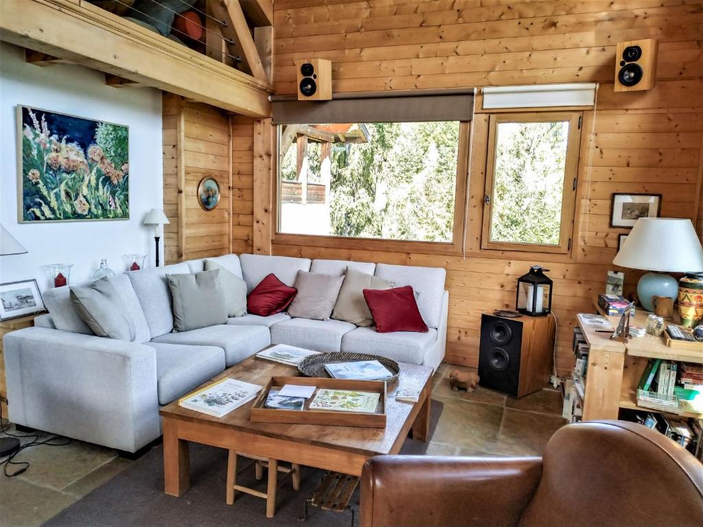 een woonkamer met een bank en een tafel bij Chalet L'Epachat by Interhome in Mémontel