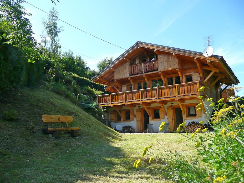 une maison en bois sur une colline avec un banc devant dans l'établissement Chalet du Bulle by Interhome, à Saint-Gervais-les-Bains