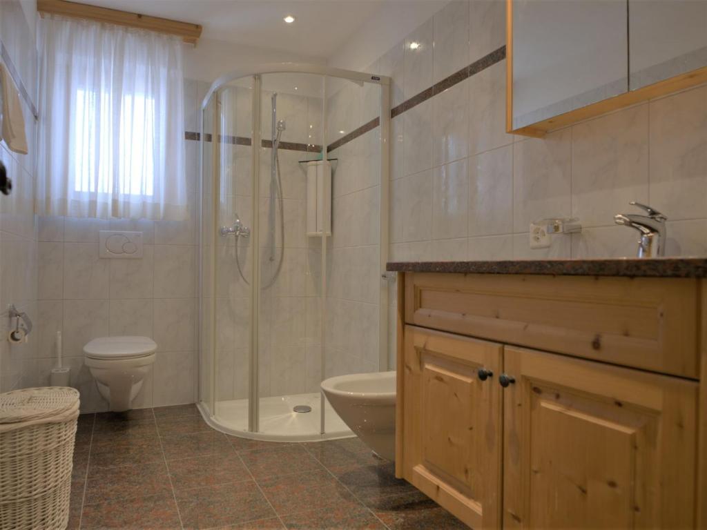 uma casa de banho com um chuveiro, um WC e um lavatório. em Apartment Chesa Dal Luf B5 by Interhome em Silvaplana