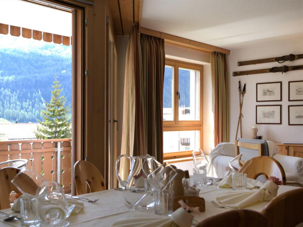 uma sala de jantar com uma mesa e uma grande janela em Apartment Chesa Dal Luf B5 by Interhome em Silvaplana