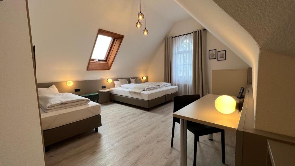 a hotel room with two beds and a table at Hotel Waldhorn in Stuttgart