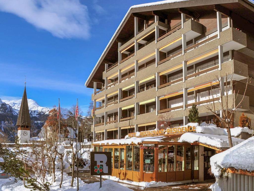a large building in the snow with a church at Apartment Residence Apt- 15 by Interhome in Wengen
