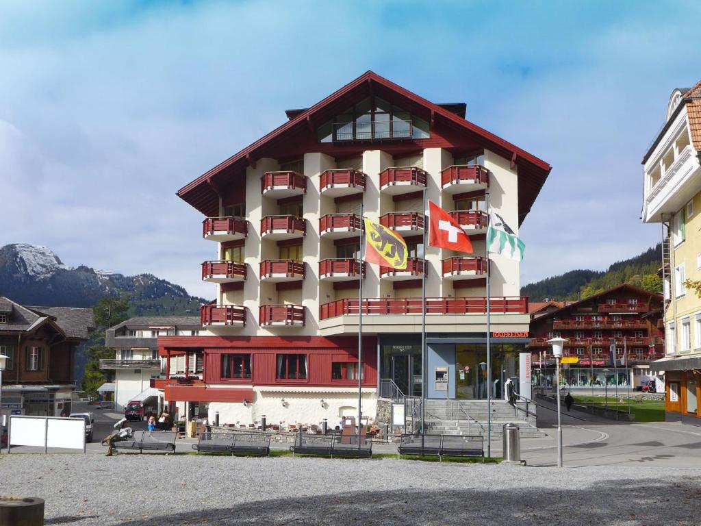 a hotel building with flags in front of it at Apartment Eiger Residence Apt-A-425 by Interhome in Wengen