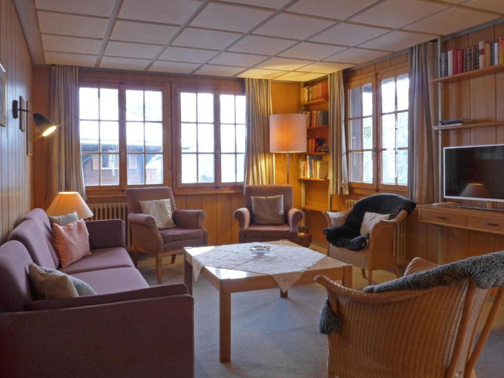 ヴェンゲンにあるApartment Drei Tannen by Interhomeのリビングルーム(椅子、テーブル、テレビ付)