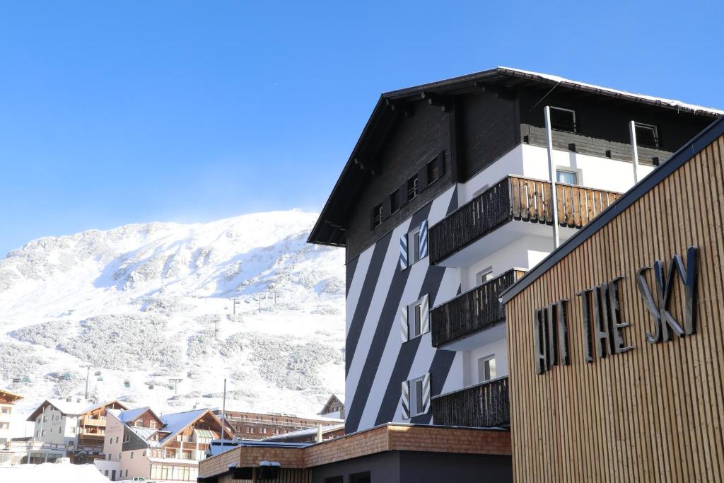 a hotel building with a snow covered mountain in the background at Hit the Sky in Sankt Christoph am Arlberg