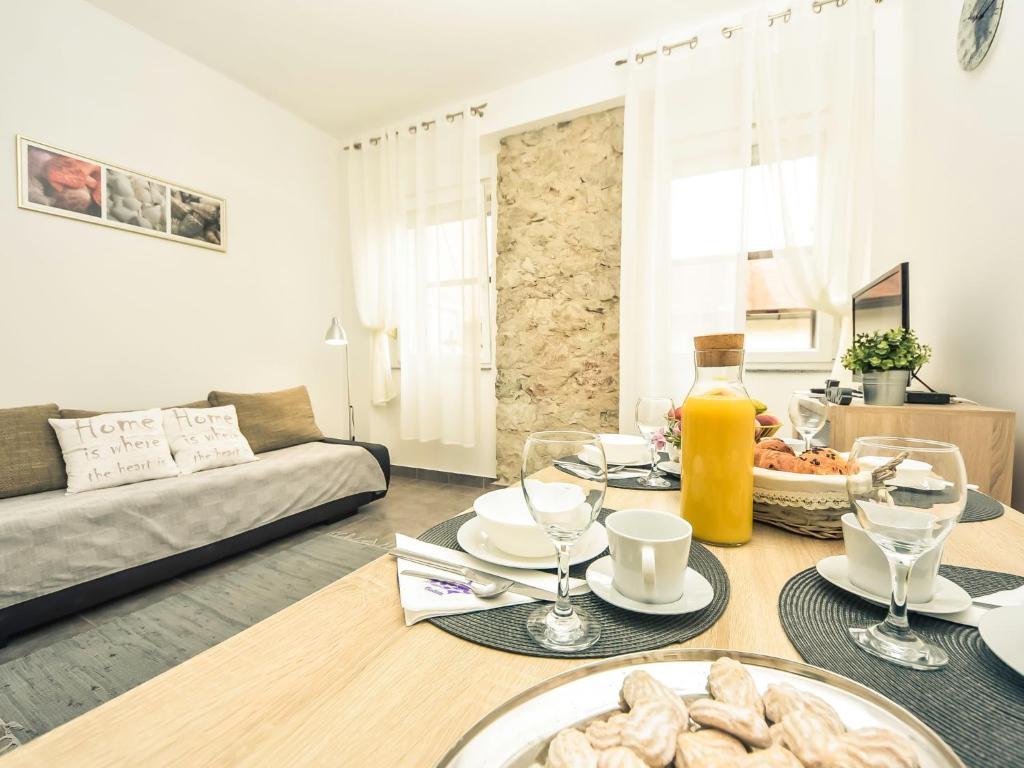 ein Wohnzimmer mit einem Tisch mit Essen drauf in der Unterkunft Apartment Snježana-1 by Interhome in Karlobag