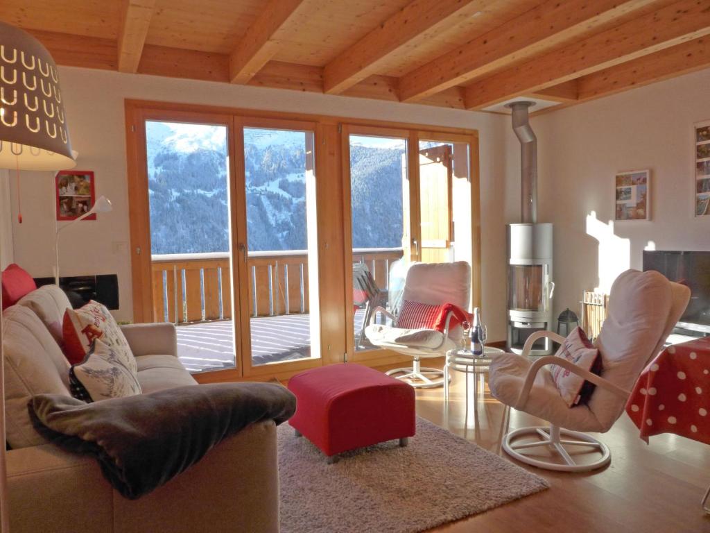 a living room with couches and chairs and a balcony at Apartment Racer's Retreat-2 by Interhome in Wengen