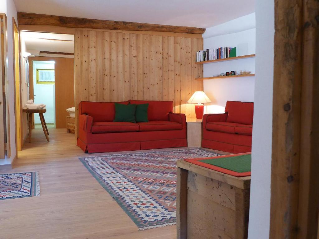 - un salon avec deux canapés rouges et un tapis dans l'établissement Apartment Chesa Frizzoni by Interhome, à Celerina