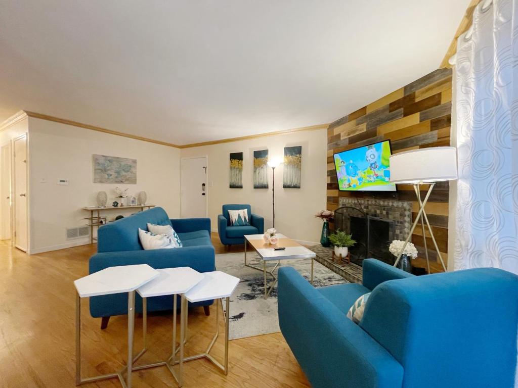 uma sala de estar com sofás azuis e uma televisão em @ Marbella Lane - 3BR Stylish House near SF em Daly City