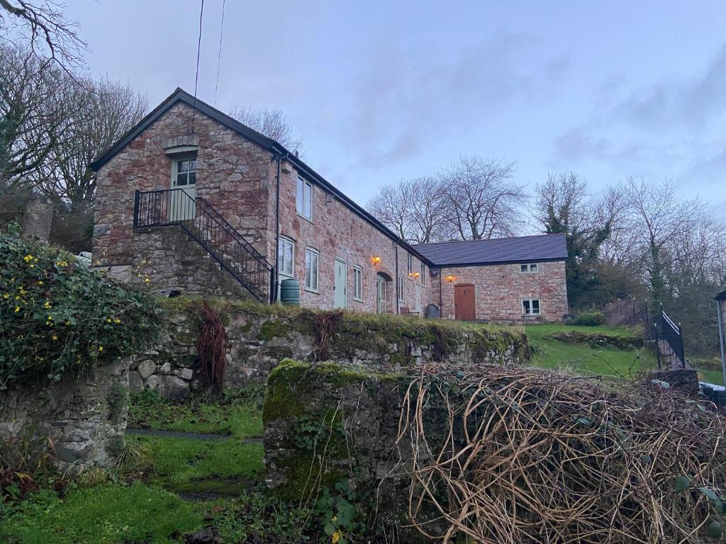 a brick building with a staircase on the side of it at Parc Farm Cottage, Flintshire, North Wales in Rhydymwyn