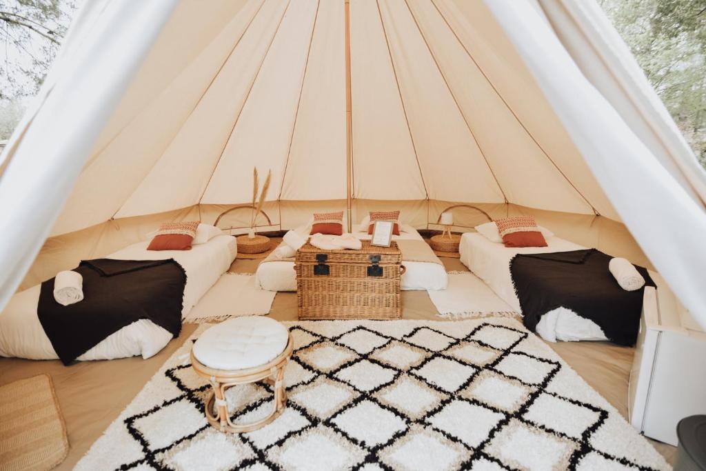 a tent with three couches and a table and a rug at Cocooning Tipi - Seignosse in Seignosse
