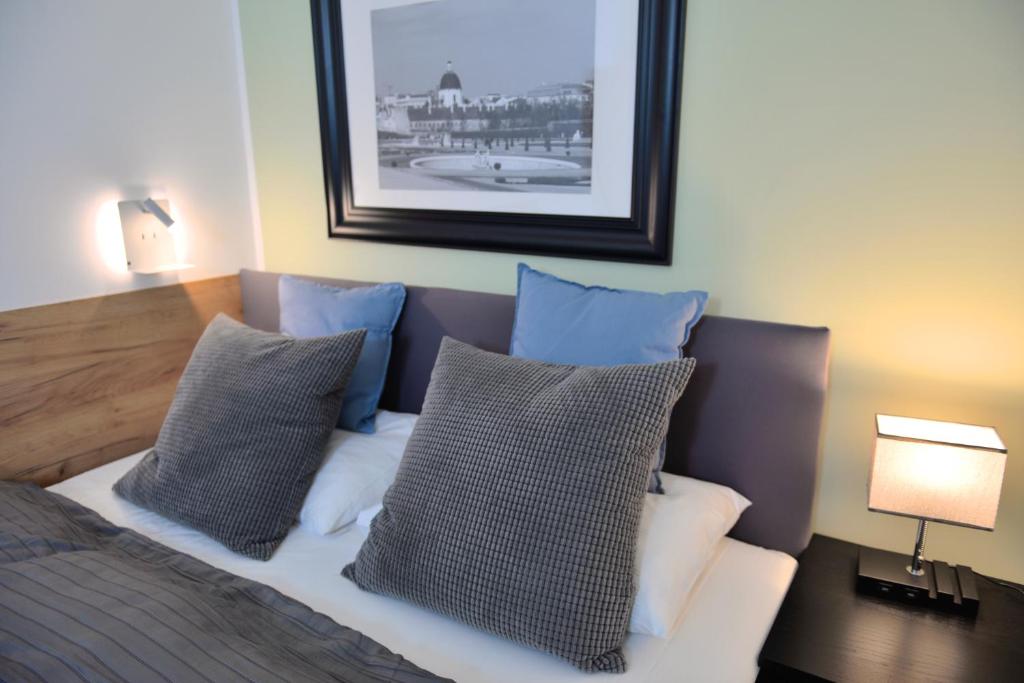 een slaapkamer met een bed met blauwe en witte kussens bij Jimmy's Apartments Suites in Wenen