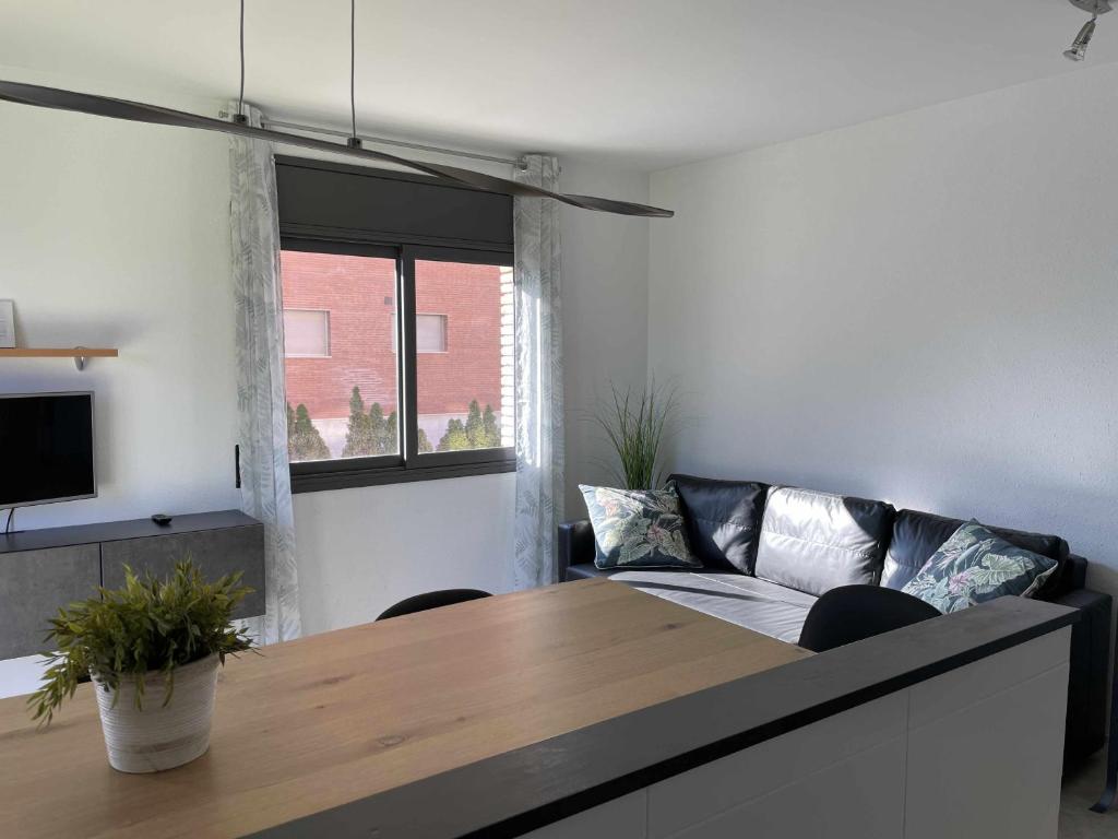 a living room with a table and a couch at Solàrium con terraza a 5 minutos de la playa in Girona