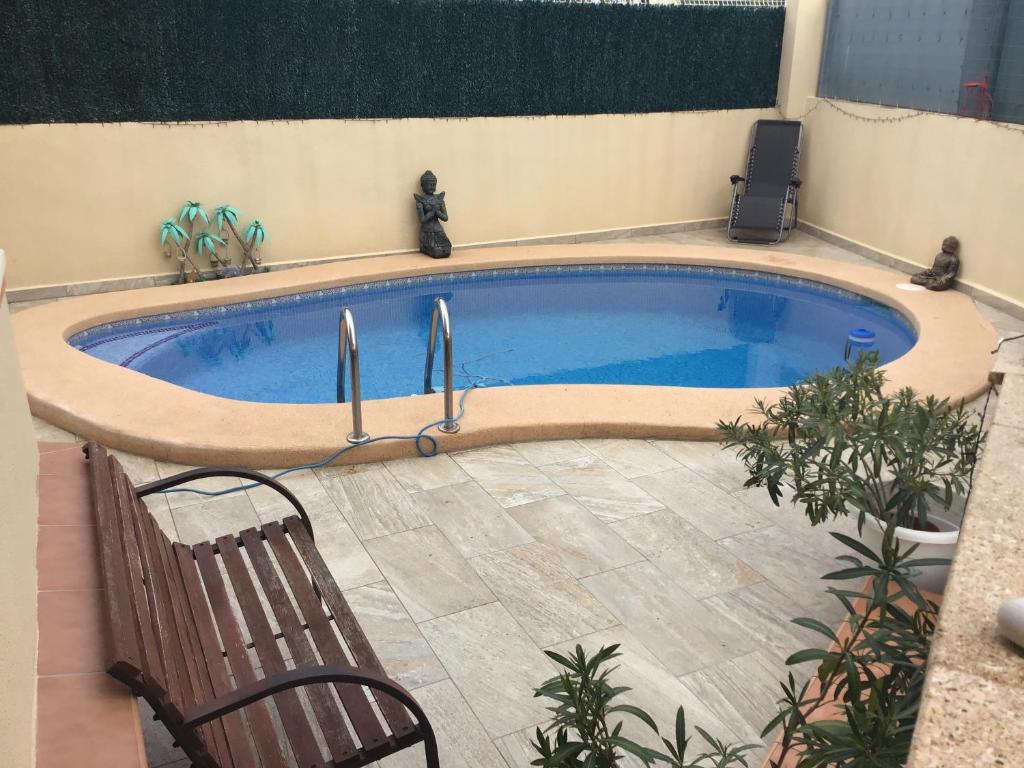 una piscina con sedia e panca accanto ad essa di Benidorm B&B Albir a Albir