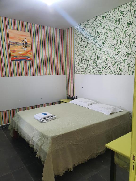 - une petite chambre avec un lit orné d'une peinture murale dans l'établissement Suíte 06 Exclusiva e Independente, à Cuiabá