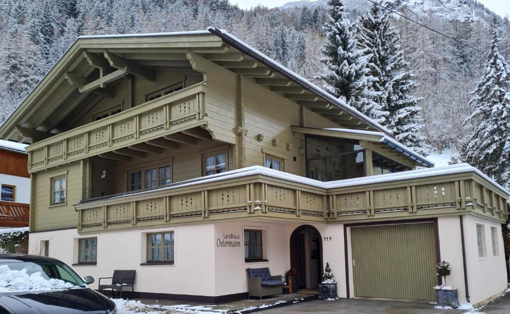una grande casa con balcone nella neve di Landhaus Ostermann a Umhausen