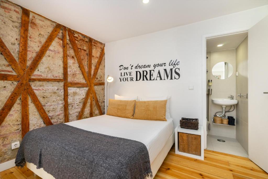 ein Schlafzimmer mit einem Bett und einer Ziegelwand in der Unterkunft WHome Martim Moniz Central Studio in Lissabon