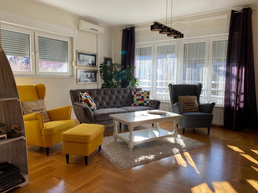 un soggiorno con divano, sedie e tavolo di Apartman Fenjer a Zagabria