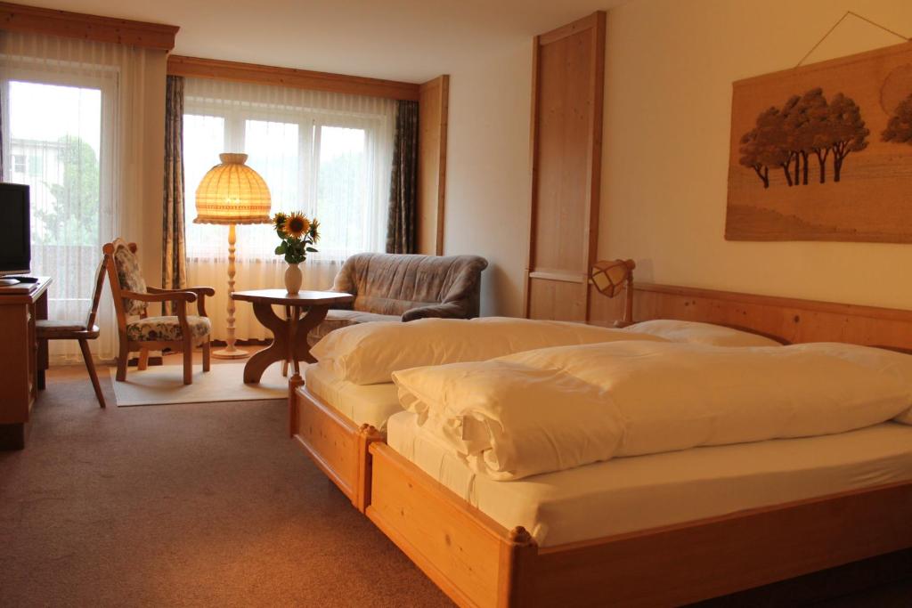 1 dormitorio con 2 camas, mesa y silla en Gemeinschaftshaus im Oberdorf, en Lützelflüh