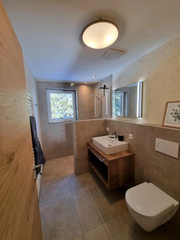 W łazience znajduje się toaleta, umywalka i lustro. w obiekcie Ferienwohnung Kurz w mieście Kössen