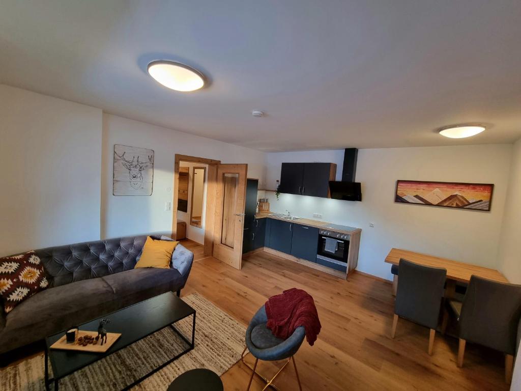 salon z kanapą i stołem w obiekcie Ferienwohnung Kurz w mieście Kössen