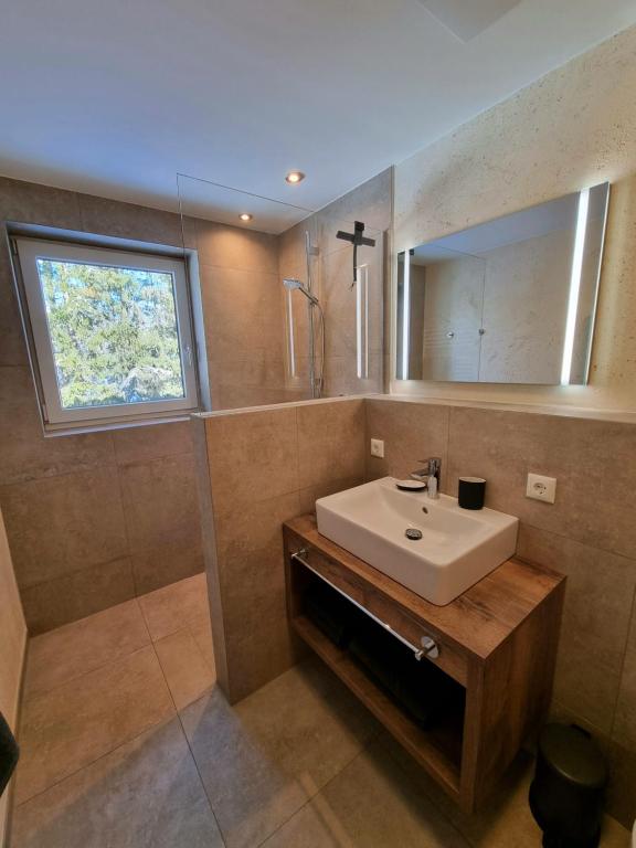 łazienka z umywalką i lustrem w obiekcie Ferienwohnung Kurz w mieście Kössen