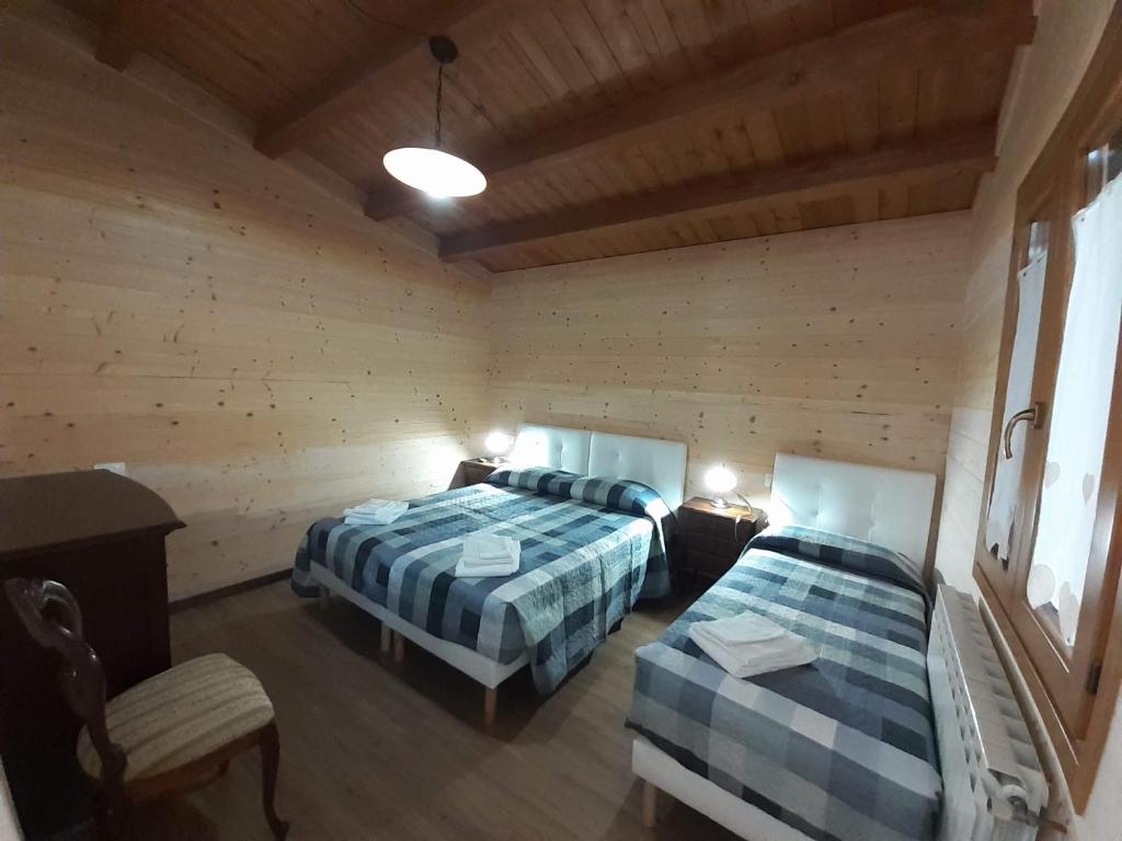 a bedroom with two beds in a wooden room at Agriturismo D'Apostolo in Amatrice