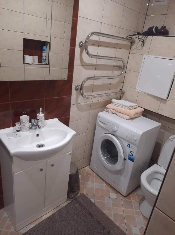 La salle de bains est pourvue d'un lave-linge et d'un lavabo. dans l'établissement Maironio Apartamentai, à Radviliškis